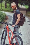 A handsome redhead male with a stylish haircut and beard dressed in sportswear and sunglasses walks in the park with a royalty free stock photo A handsome redhead male with a stylish haircut and beard dressed in sportswear and sunglasses walks in the park with a royalty free stock photo