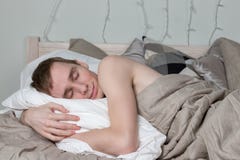 Handsome young adult man sleeping in bed. guy is resting stock photography Handsome young adult man sleeping in bed. guy is resting stock photography