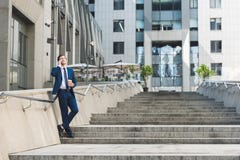 handsome young businessman in stylish suit with coffee to go talking by phone on stairs royalty free stock image handsome young businessman in stylish suit with coffee to go talking by phone on stairs royalty free stock image