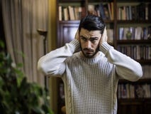 Handsome young man covering his ears, too much noise stock images Handsome young man covering his ears, too much noise stock images