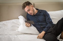 Handsome young man at home reading with ebook royalty free stock photo Handsome young man at home reading with ebook royalty free stock photo