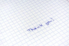 Handwritten inscription Thanks to the blue pen on a sheet in a cage royalty free stock photos Handwritten inscription Thanks to the blue pen on a sheet in a cage royalty free stock photos