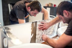 Handyman που καθορίζει και που εφαρμόζει τα κεραμικά κεραμίδια στους τοίχους λουτρών στοκ φωτογραφίες με δικαίωμα ελεύθερης χρήσης Handyman που καθορίζει και που εφαρμόζει τα κεραμικά κεραμίδια στους τοίχους λουτρών στοκ φωτογραφίες με δικαίωμα ελεύθερης χρήσης