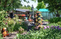 Hangar de jardin et maison verte entourés par un beau décoratif Image stock Hangar de jardin et maison verte entourés par un beau décoratif Image stock