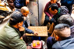 Hanoi Vietnam - Februari 13 2018: Två män som spelar den strategiska brädeleken för två kallade spelare, går i gatorna av Hanoi arkivfoto Hanoi Vietnam - Februari 13 2018: Två män som spelar den strategiska brädeleken för två kallade spelare, går i gatorna av Hanoi arkivfoto