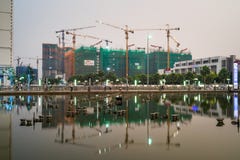 Hanoi, Vietname - 10 de maio de 2016: Sob construções da construção com reflexão do período na cidade crepuscular às vezes, rua d imagens de stock Hanoi, Vietname - 10 de maio de 2016: Sob construções da construção com reflexão do período na cidade crepuscular às vezes, rua d imagens de stock