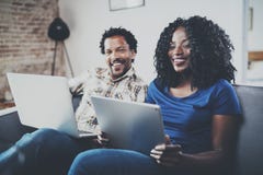 Happy african american couple relaxing together on the sofa.Young black man and his girlfriend using laptop at home in Royalty Free Stock Photos Happy african american couple relaxing together on the sofa.Young black man and his girlfriend using laptop at home in Royalty Free Stock Photos