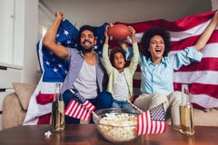 African American family of three watching tv and cheering sport games on sofa at home royalty free stock images African American family of three watching tv and cheering sport games on sofa at home royalty free stock images