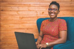 Happy African-American Lady working with laptop at home