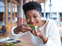 Happy african american woman eating pizza stock photos Happy african american woman eating pizza stock photos