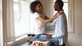 Happy african romantic young couple having fun embracing in kitchen