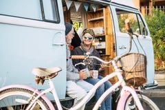 Happy And Cheerful Senior People Couple Enjoy The Travel And Retired Lifestyle Taking A Coffee Together Inside An Old Van With A Royalty Free Stock Photo