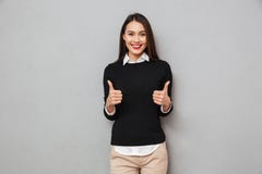 Happy asian business woman in business clothes showing thumbs up