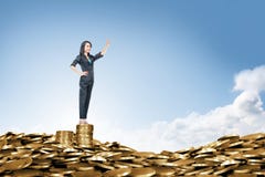Happy asian business woman standing on the peak of coin pile royalty free stock photo Happy asian business woman standing on the peak of coin pile royalty free stock photo
