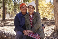 Happy Asian couple sitting in a forest looking to camera Royalty Free Stock Images Happy Asian couple sitting in a forest looking to camera Royalty Free Stock Images