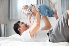 Happy asian family father with baby son playing on bed with smil royalty free stock image Happy asian family father with baby son playing on bed with smil royalty free stock image