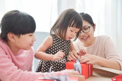 Happy Asian family wrapping a gift box. royalty free stock image Happy Asian family wrapping a gift box. royalty free stock image