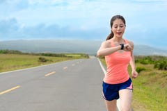 Happy attractive girl runner using smartwatch Royalty Free Stock Photography Happy attractive girl runner using smartwatch Royalty Free Stock Photography