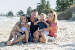 Happy beautiful Caucasian family having holidays on the beach smiling with mother and father sitting on sand with little son and y Stock Photos Happy beautiful Caucasian family having holidays on the beach smiling with mother and father sitting on sand with little son and y Stock Photos