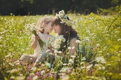 Happy beautiful mother lady posing with her cute little daughter in lovely scene of family summer life on meadow of daisy poppy f stockbild Happy beautiful mother lady posing with her cute little daughter in lovely scene of family summer life on meadow of daisy poppy f stockbild