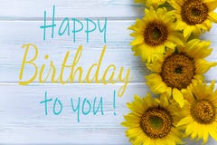 Happy Birthday. Greeting card with flowers for a girl, mom`s birthday. View from above. Sunflower flowers on a light wooden