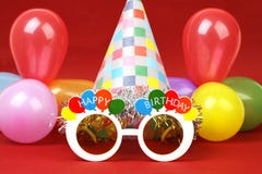 Happy birthday party glasses, party hat and party balloons on red background stock image Happy birthday party glasses, party hat and party balloons on red background stock image