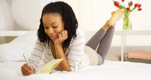Happy black woman writing in journal Royalty Free Stock Photos Happy black woman writing in journal Royalty Free Stock Photos