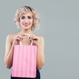 Happy blonde woman holding pink shopping bags and smiling royalty free stock photos Happy blonde woman holding pink shopping bags and smiling royalty free stock photos