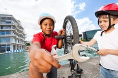 Happy boys fixing bike together outdoors in summer royalty free stock image Happy boys fixing bike together outdoors in summer royalty free stock image