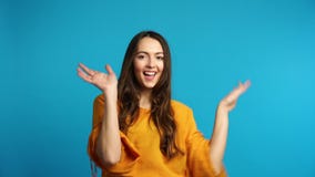 Happy carefree woman dancing on blue background stock video footage Happy carefree woman dancing on blue background stock video footage