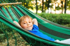 Happy Child Boy Lying In A Hammock In Garden. Summer Holidays Concept. The Child Is Resting In Nature. Cute Kid Enjoy Summer Royalty Free Stock Image