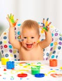 Happy child draws with colored paints hands