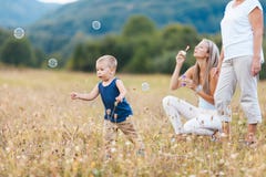 Happy child with family having a great time blowing bubbles royalty free stock image Happy child with family having a great time blowing bubbles royalty free stock image
