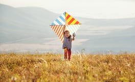 Happy child girl running with kite at sunset outdoors Stock Image Happy child girl running with kite at sunset outdoors Stock Image