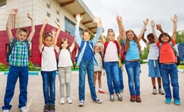 Happy children with arms up standing near school royalty free stock photo Happy children with arms up standing near school royalty free stock photo