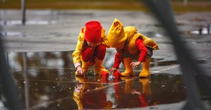 Happy children girl and boy with paper boat in puddle in autumn Stock Photo Happy children girl and boy with paper boat in puddle in autumn Stock Photo