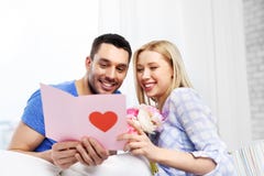 Happy couple with greeting card and flowers royalty free stock images Happy couple with greeting card and flowers royalty free stock images
