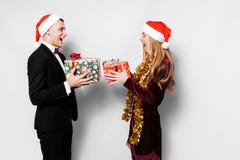 A happy couple of lovers in Santa Claus hats giving each other C stock photography A happy couple of lovers in Santa Claus hats giving each other C stock photography