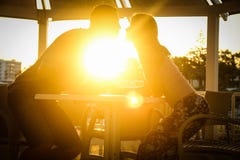 Happy couple at a table by the sea at sunset nature royalty free stock photos Happy couple at a table by the sea at sunset nature royalty free stock photos