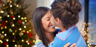 Happy daughter kissing her mother on christmas stock photos Happy daughter kissing her mother on christmas stock photos