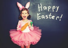 Happy Easter! child girl in costume bunny with carrot about bla royalty free stock photo Happy Easter! child girl in costume bunny with carrot about bla royalty free stock photo