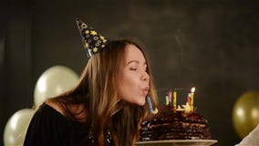 Happy Emotional Girl Blows out Candles During Celebration Her Birthday and Applauds. Close up Portrait of Young Lady stock video footage Happy Emotional Girl Blows out Candles During Celebration Her Birthday and Applauds. Close up Portrait of Young Lady stock video footage