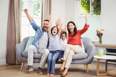 Happy family cheering while siting on sofa royalty free stock images Happy family cheering while siting on sofa royalty free stock images