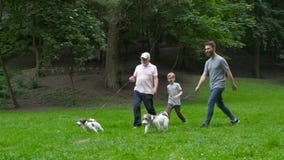 Happy family of father grandfather and son with Jack russel terrier dog having fun, laughing, running, walking together