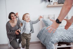 Happy family is having fun at home. Mother, father and little daughter with plush toy are enjoying being together stock photo Happy family is having fun at home. Mother, father and little daughter with plush toy are enjoying being together stock photo