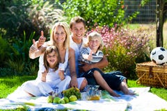 Happy family having a picnic with thumbs up