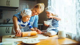 Happy family in kitchen. mother and children preparing dough, ba Stock Photo Happy family in kitchen. mother and children preparing dough, ba Stock Photo