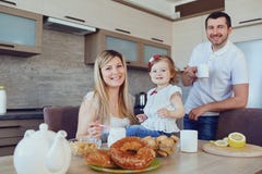 A happy family in the kitchen while sitting at a table. stock photography A happy family in the kitchen while sitting at a table. stock photography