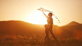 happy family mother and child run on meadow with a kite in summer stock photo happy family mother and child run on meadow with a kite in summer stock photo