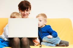 Happy family. Mother and sons using laptop sitting on sofa at home Stock Photo Happy family. Mother and sons using laptop sitting on sofa at home Stock Photo